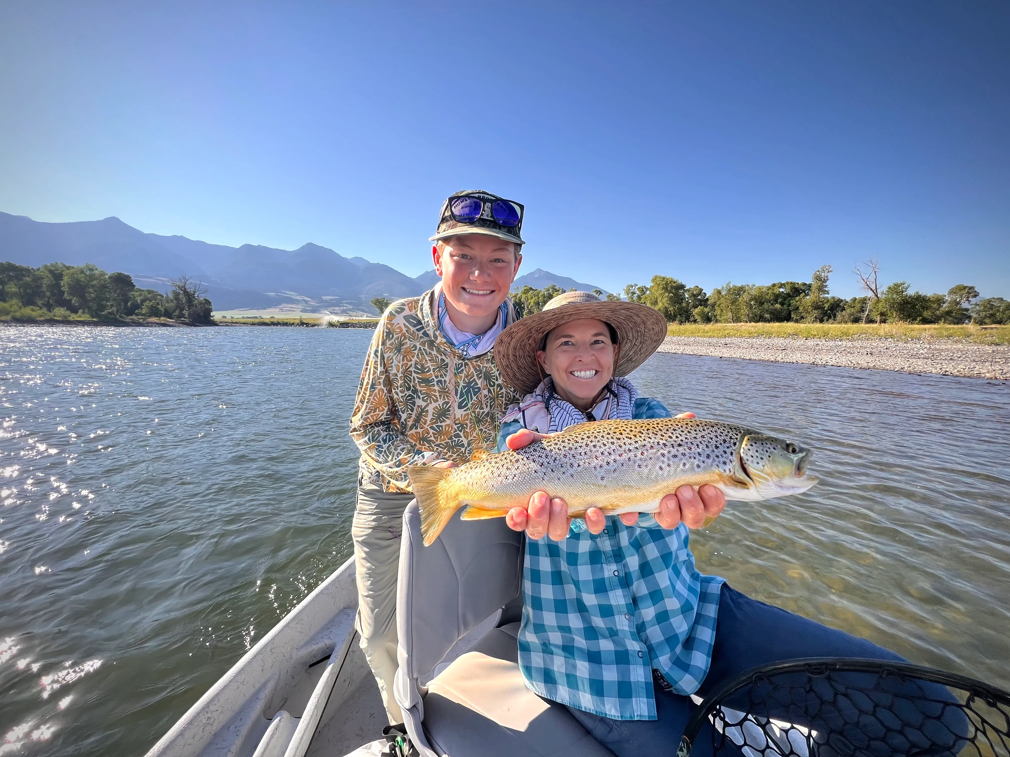 Couple with a beautiful brown trout on the boat