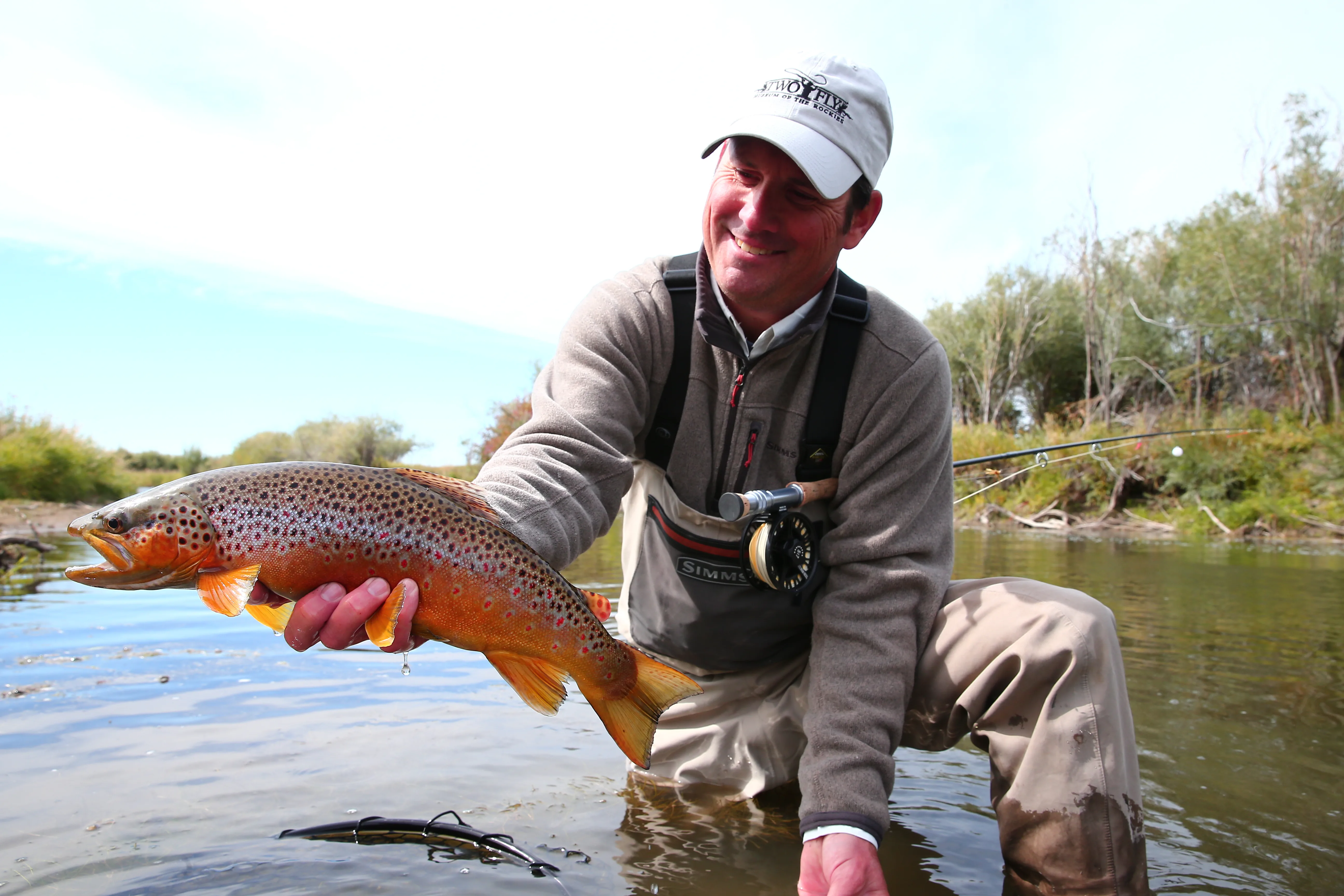 Client with a trophy brown trout streamside